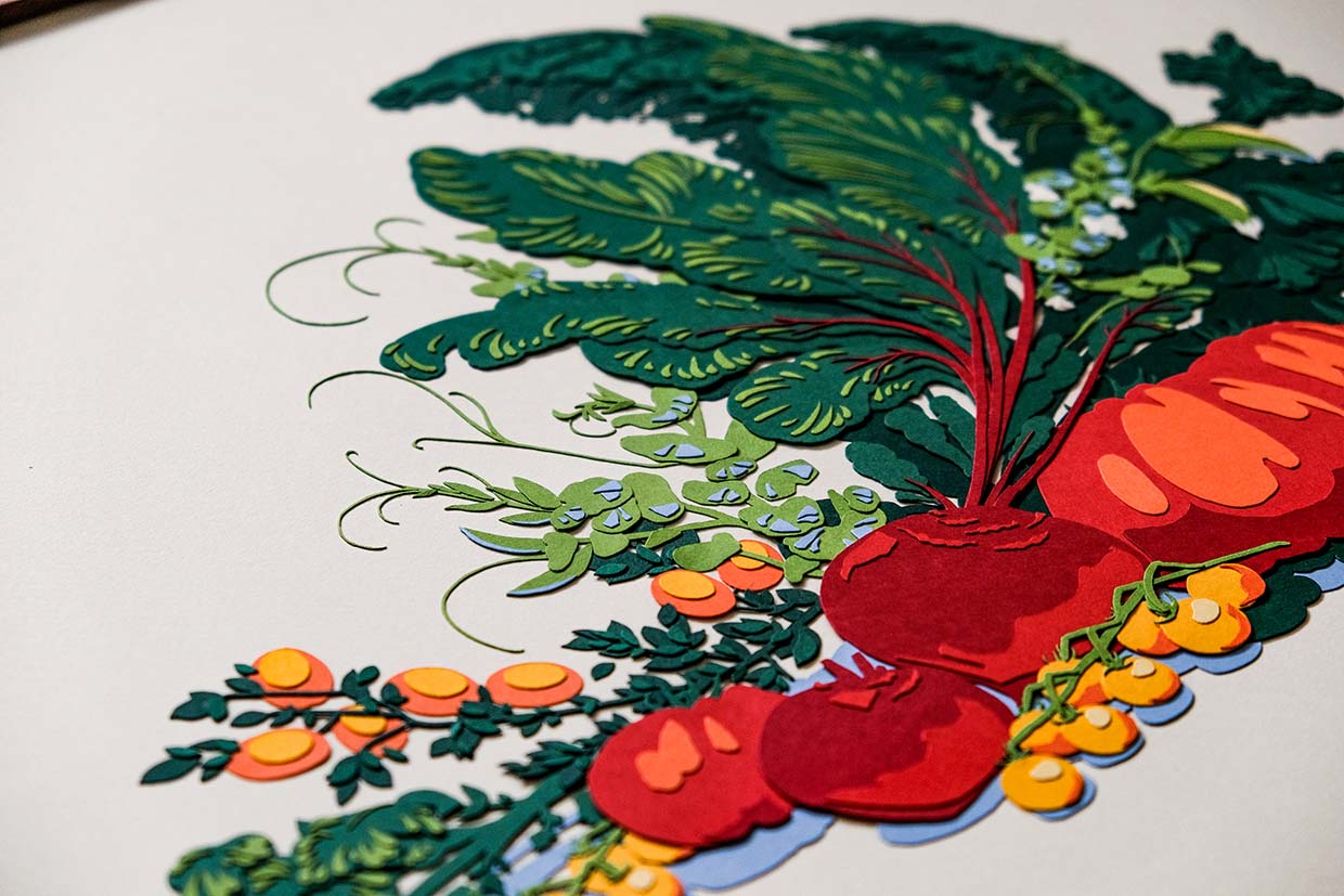 An angled view of the artwork shows the layered textures of the beets, tomatoes, and leafy greens.