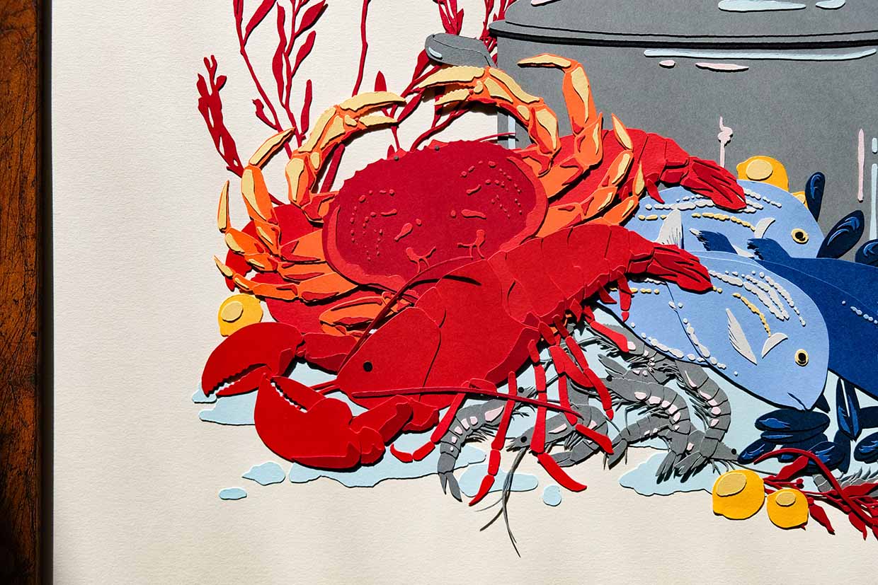 The lobster is made of red paper with dark red detailing, with each shell plate layered one above the other. The crab is decorated with various paper details of oranges and yellows.