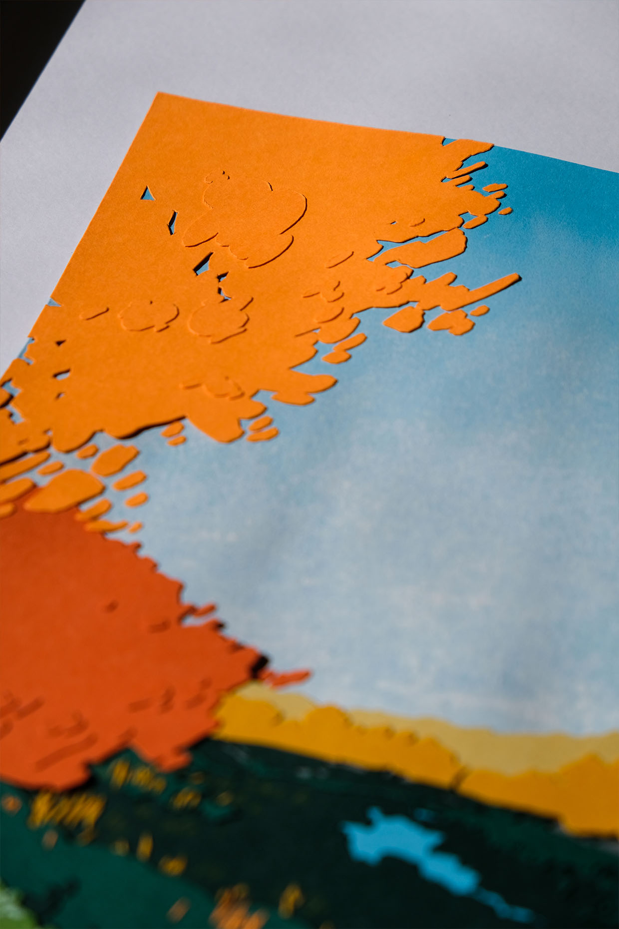 Another detail view shows layers of golden orange paper leaves against a hazy blue sky.