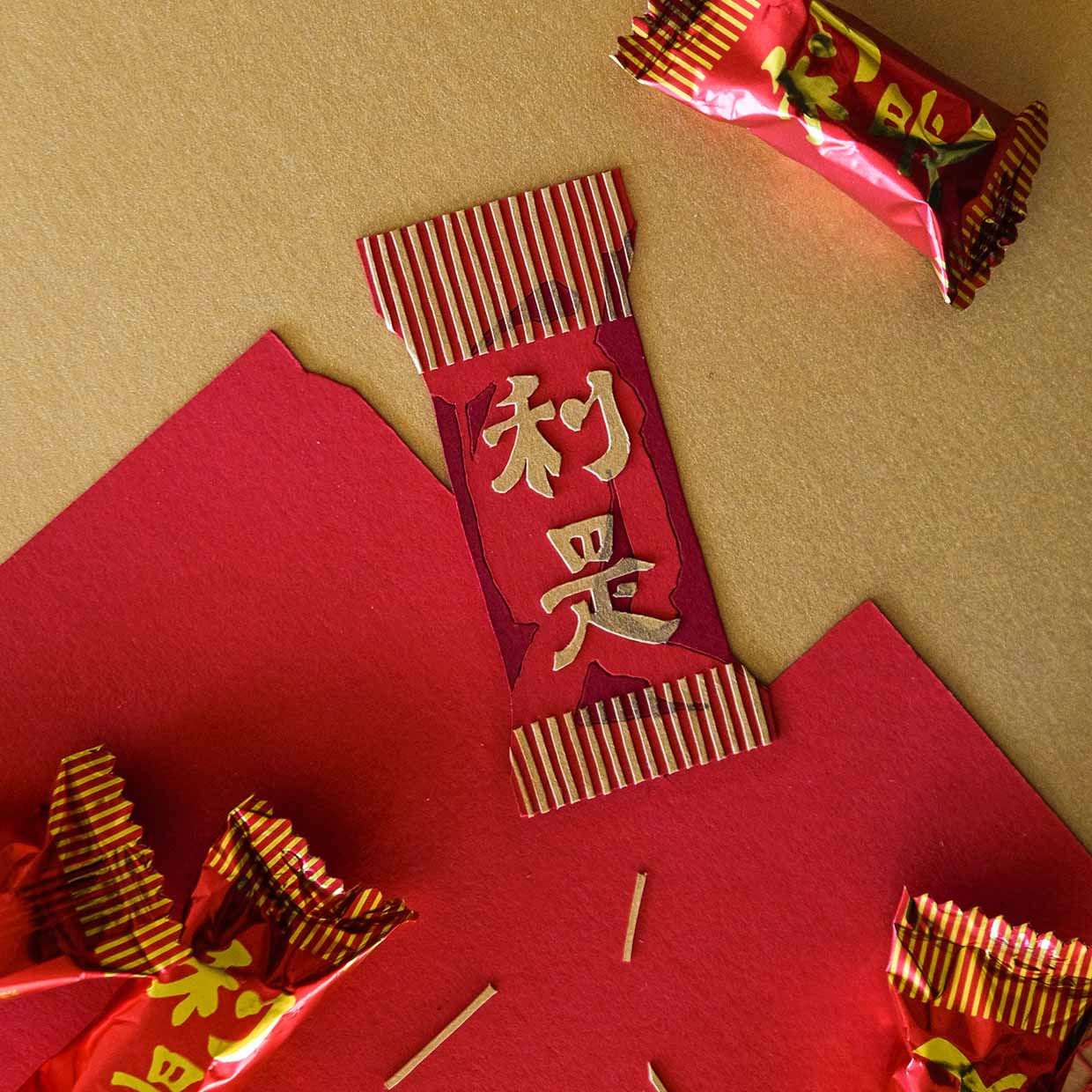 A paper reproduction of the iconic Garden-brand strawberry-flavored candy is nestled in the midst the real candies and bits of gold and red paper.