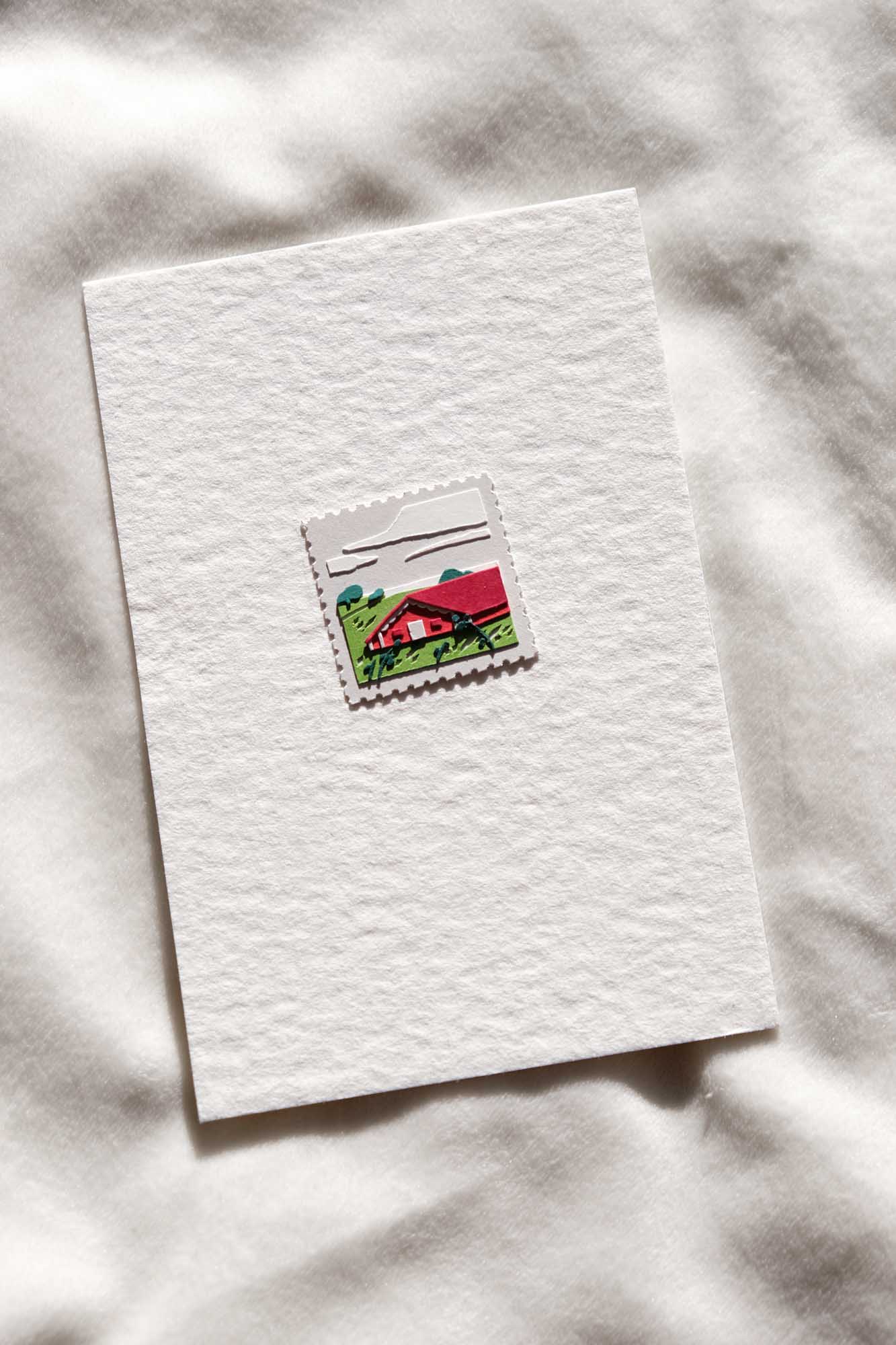 The fifth stamp reimagines the western side of the city in another era, when a red dairy barn might have presided over a field of green grasses and brush.