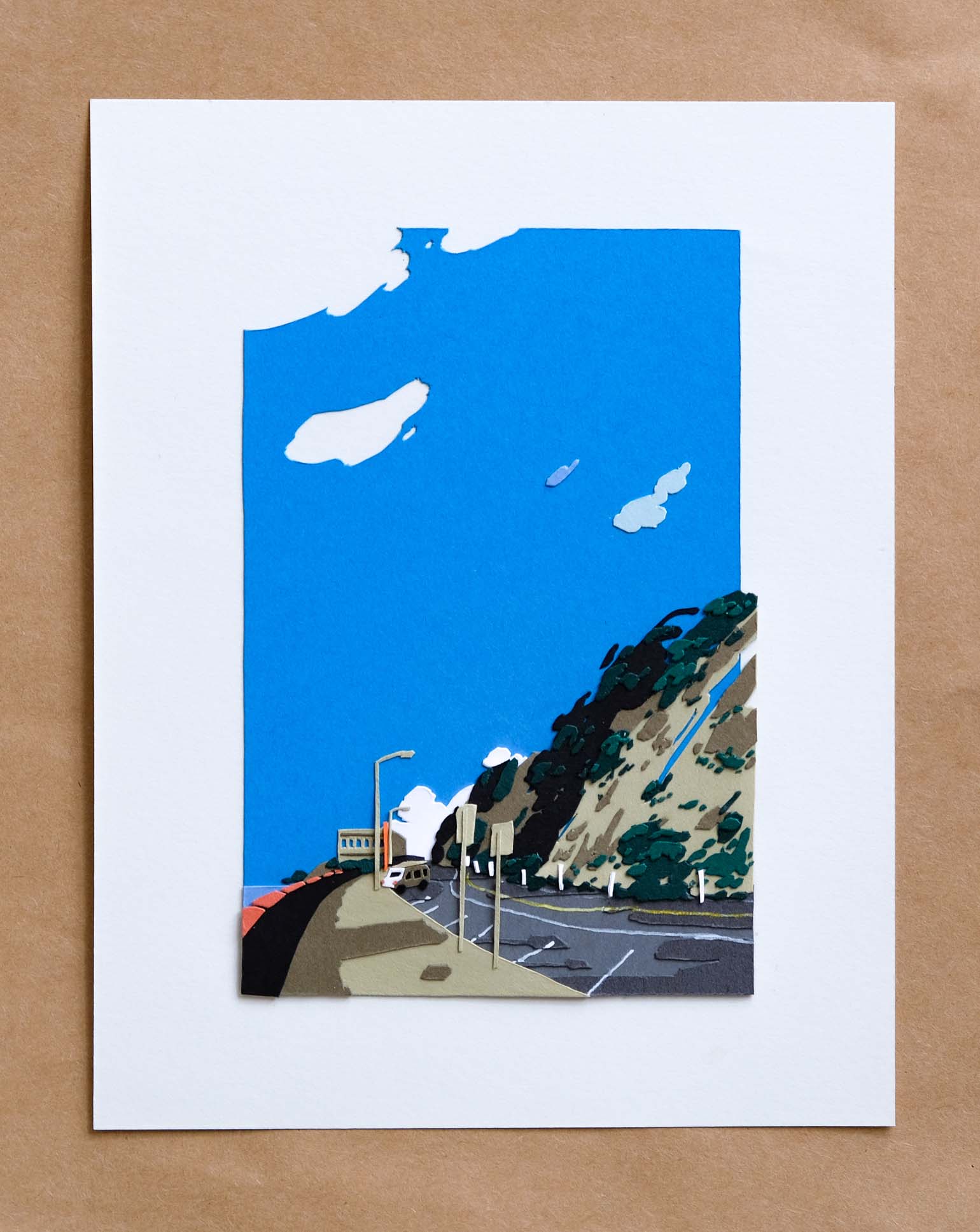 An empty paper road winds along the western coastline of San Francisco under a vast blue sky. Cliffs are covered in layers of paper shrubbery, and a lonely car sits parked next to the dormant Cliff House.